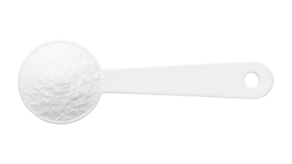 White measuring scoop filled with baking flour, close-up of baking and cooking ingredients