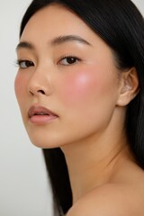Fototapeta premium Close-up of stunning Asian woman with radiant complexion and rosy blush for beauty, skincare, and cosmetics advertising campaigns or editorial content