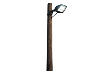 Wooden utility pole with modern led streetlight illuminating urban night scene on transparent background