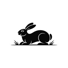 A clean and elegant black silhouette illustration of a rabbit resting in a grassy meadow. The artwork highlights smooth curves, expressive details, and a natural pose, creating a simple yet charming d