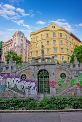 Fototapeta premium a historic stone staircase and archway covered in colorful graffiti
