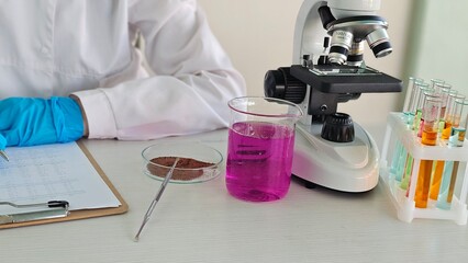Laboratory analysis in progress with colorful liquids and a microscope concept