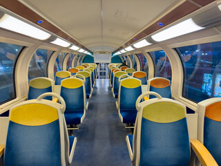 Fototapeta premium Modern train interior showcasing empty seats in a vibrant atmosphere