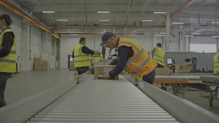 Logistics workers sort boxes on a conveyor system in a busy warehouse environment - Powered by Adobe