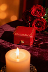 Romantic tennis-themed setting with red roses, a candle, and a decorative box for a special occasion