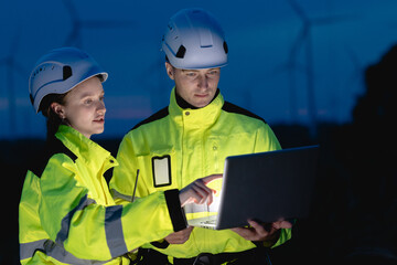 Professional engineer team at night shift. Workers in wind turbine. Technician work survey inspector