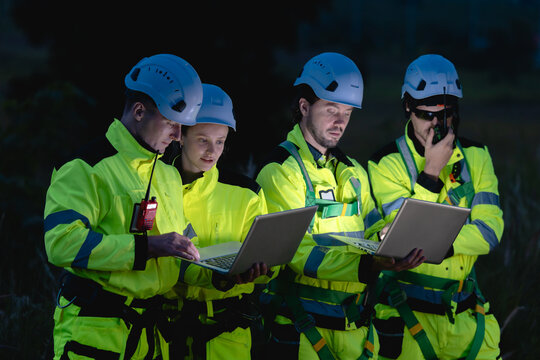 Professional engineer team at night shift. Workers in wind turbine. Technician work survey inspector