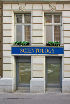 blue and gold Scientology signage on the ground floor of a classic Vienna building facade