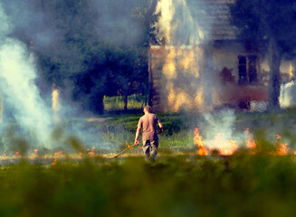 Mężczyzna wypala trawy na polu po zebraniu plonów. Wypalanie traw jest czynnością bardzo ryzykowną i szkodliwą dla środowiska © JDziedzic