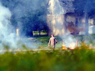 Mężczyzna wypala trawy na polu po zebraniu plonów. Wypalanie traw jest czynnością bardzo ryzykowną i szkodliwą dla środowiska © JDziedzic