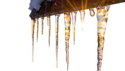 Long, translucent icicles hang from a roofline against a bright, warm-toned background