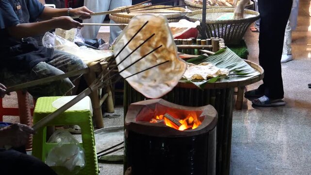 Grilling traditional Thai rice cracker