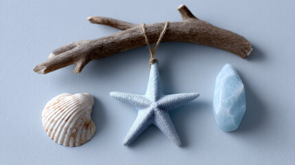 Coastal flatlay with starfish ornament hanging on driftwood, seashell and blue sea glass on light background, natural beach decor