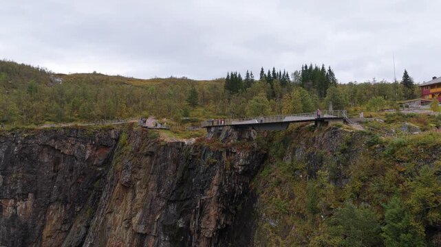 Drone shot of tourists exploring Voringfossen waterfall platforms, Norway