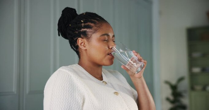 Glass, drinking water and pills with black woman in kitchen of home for detox drinks, medicine and health. Supplements, wellness and treatment with person in apartment for liquid and beverage