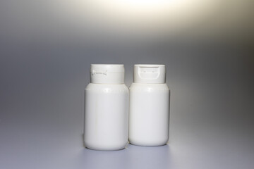 White plastic bottles displaying blank space for product branding