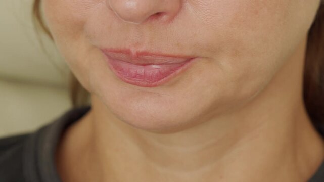 A person is shown in a close-up, opening their mouth in the initial moments of a yawn. The action is an expression of tiredness or boredom. The sound is a quiet exhale, breath, or the start of a yawn.