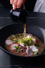 Soup Bowl With Radish, Beef, Eggs, Greens, And Delicate Golden Broth Pour