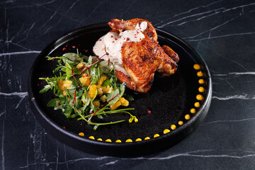 Roasted Chicken Leg Plate with Fresh Greens and Sauces on Dark Marble