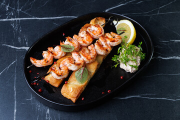 Gourmet Shrimp Skewers on Crispy Bread with Lemon Wedge and Fresh Green