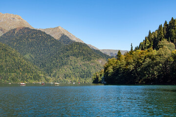 Lake Ritsa, located in the highlands, is stunning in its beauty. Its turquoise surface reflects the sky. The mountain slopes are covered with dense forest.