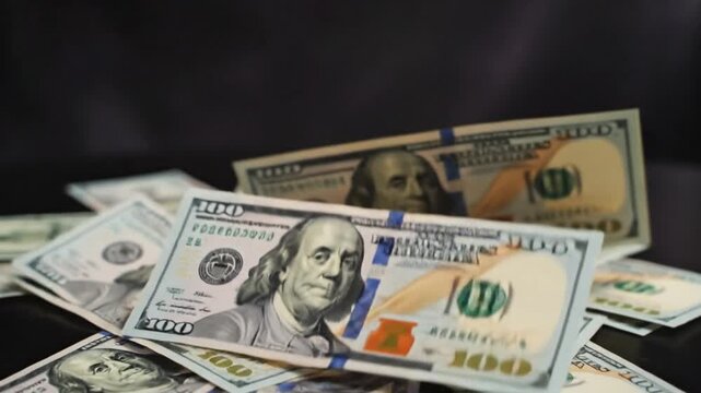 A close-up view of United States currency, focusing on the iconic $100 bill, arranged to create a captivating composition that represents wealth, finance, and economic success.