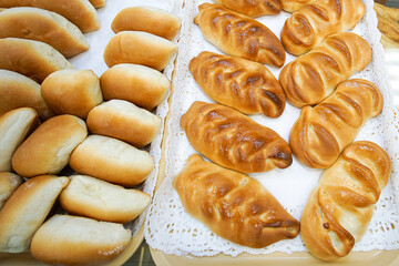 In the shop window there are pies and buns on trays with napkins.