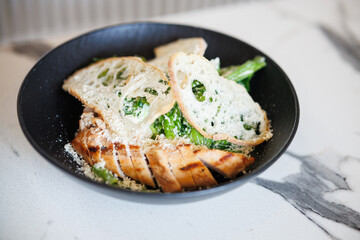 Grilled Chicken With Greens And Toasted Bread In A Black Bowl