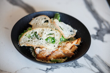 Grilled Chicken With Greens And Toasted Bread In A Black Bowl