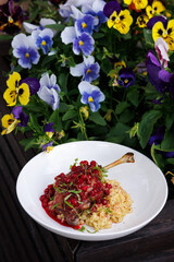 Lamb Rack With Pomegranate Glaze And Creamy Risotto In A Colorful Garden Setting