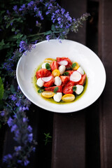 Bright Tomato Burrata Salad With Radish Slices and Olive Oil Drizzle