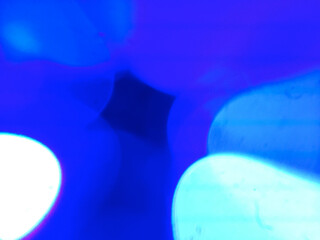 Enchanting blue-cyan bokeh composition featuring bright white-cyan luminous spheres creating cool-tone layered bokeh effect and sophisticated atmospheric glow. Authentic film light leak showcasing mul