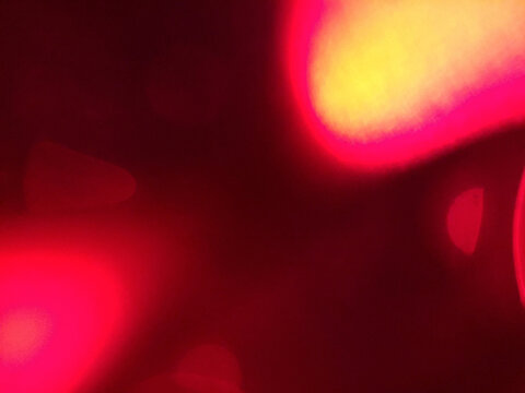 Spectacular warm-toned multi-bokeh cluster featuring pink, yellow, and red glowing spheres creating layered bokeh effect and rich color saturation against dark background. Authentic film photography 