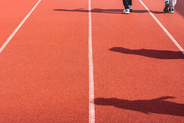 Fototapeta premium Red synthetic rubber running track for sports outdoors. Close Up of an athlete on a track or jogging track in Surabaya Stadium, Indonesia. Running track red texture background. Top View.