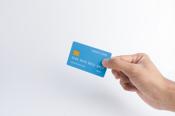 Hand holding a blue credit card with a visible microchip on a white background, symbolizing secure digital payment, contactless transaction, quick commerce, or banking service.
