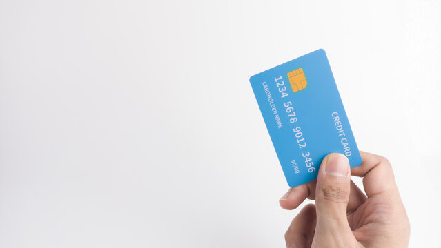 Hand holding a blue credit card on a white background with large copy space, symbolizing secure digital payment, banking services, quick commerce, or finance advertising.
