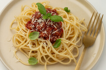Close-up of a plate with pasta and bolognese sauce on a white background