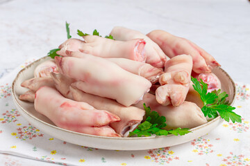 Pork trotters arranged on a plate with fresh parsley on a white background