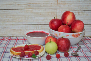 apple jam with raspberries composition, plate with red apples and raspberries and jam with bread
