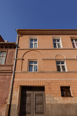 Old Narrow Residential Building with Weathered Orange Facade in the Historic Center of Gniezno, Poland. Tourism and Travel Destination