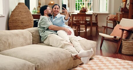 Kiss, happy couple and selfie in home for love, social media update or funny memory on sofa. Smile, man and woman with photo in living room for romantic relationship, laugh and relax with partner - Powered by Adobe