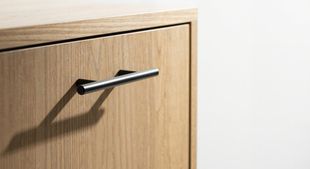 Modern wooden cabinet with sleek handle detail and soft lighting for interior design concept