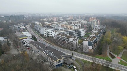 Helicopter flying over cityscape, showcasing urban environment with buildings and greenery, camera pans smoothly to capture aerial view and scene progression