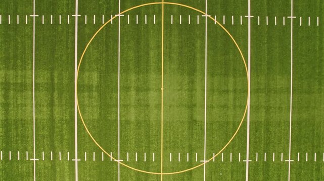 Soccer field top straight down aerial shot zoom out. Empty football playground. Sport stadium green grass and white paint lines and marks for games and activity. Healthy lifestyle.