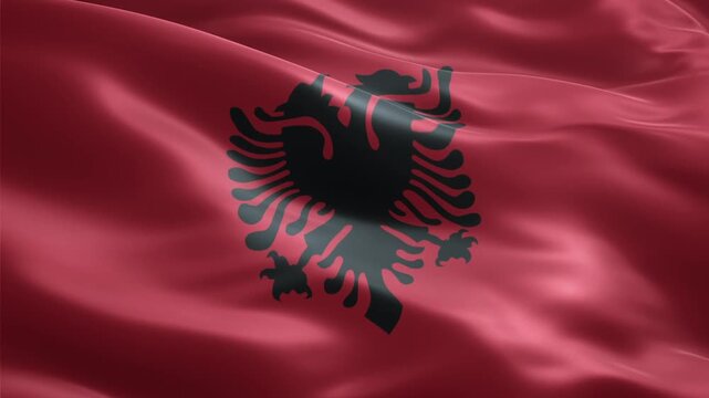 The national flag of Albania, featuring a black double-headed eagle on a vibrant red background, waving gracefully in the wind.