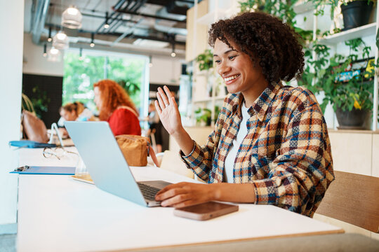 A Young Woman Engaged in Work on Her Laptop While Seated in a Contemporary Cafe Environment