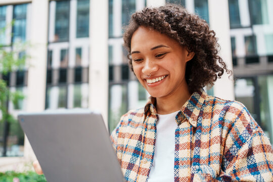 A Young Woman Engaged with Her Tablet in a Vibrant Urban Environment Full of Life
