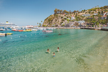 Siblings swimming in tropical beach vacation