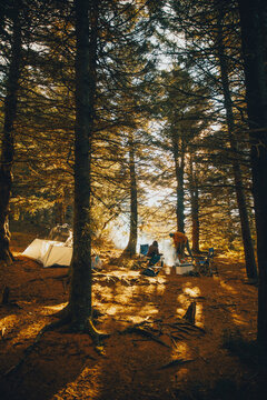 Couple camping in moody mountains and firepit smoke