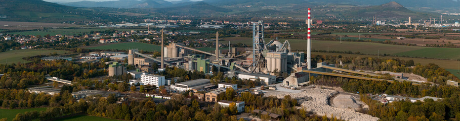 Aerial view of large cement factory complex with industrial smokestacks and quarry, Lafarge cement plant, Czech Republic